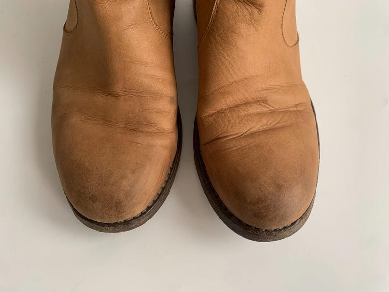 May include: A pair of brown leather ankle boots with a pointed toe and a low heel.