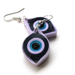 May include: A pair of lavender and black paper quilled earrings with a blue and black eye design.