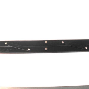 May include: A black, adjustable drafting tool with silver rivets and hinges. The tool has a rectangular shape and is designed for precise measurements and angles. Text is visible on the tool's surface.
