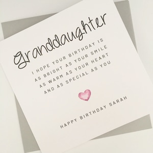 Può includere: Biglietto di compleanno per una nipote con la parola "granddaughter" in carattere scritto a mano. Il biglietto include un messaggio e un cuore rosa ad acquerello. Le parole "Happy Birthday Sarah" sono in basso.
