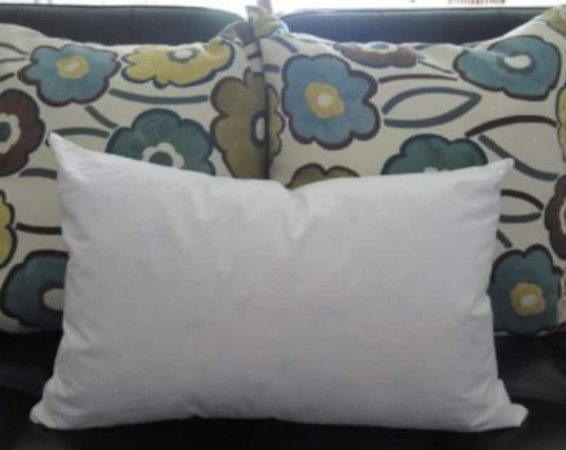 May include: A white down pillow, a standard size pillow, for sleeping or resting on a couch.
