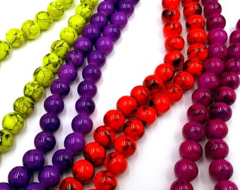 May include: A strand of colorful round beads with a marbled effect. The beads are in shades of purple, red, yellow, and pink.