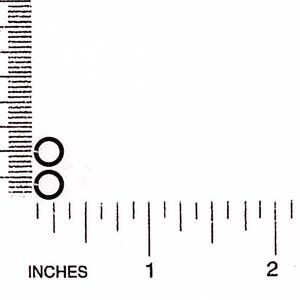 May include: Two small, black, circular objects are positioned near the 10 mm mark on a ruler. The ruler displays both inches and millimeters, with the inch markings below the millimeter markings.