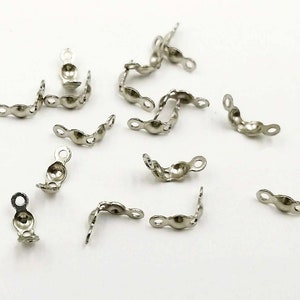 Può includere: Connettori d'angolo in metallo argentato per la creazione di gioielli. I connettori hanno una forma arrotondata e due anelli su ogni lato.