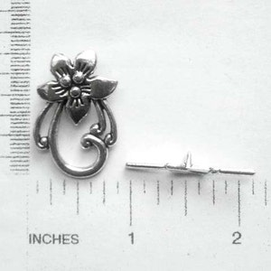 May include: Silver-toned metal flower charm with a decorative swirl design. The charm is approximately 1 inch in length and includes a jump ring for attaching to jewelry or other crafts.