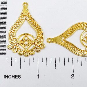 May include: Two gold-tone metal earring findings with a decorative filigree design. The findings are approximately 1 inch in length.