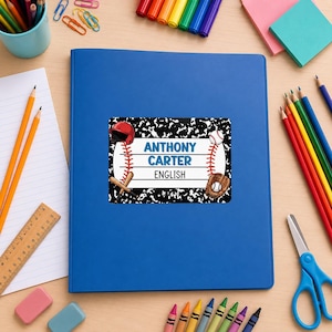 May include: A rectangular name label sticker featuring a black and white composition notebook pattern background. The label displays a baseball theme with a red helmet, a baseball, a glove, and two bats. The text reads ANTHONY CARTER and ENGLISH.