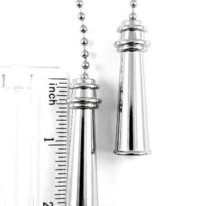 May include: Two silver-colored light pull chains with decorative lighthouse-shaped pulls. The pulls are approximately 2 inches (5 cm) long. The chains are attached to a series of small, round beads.