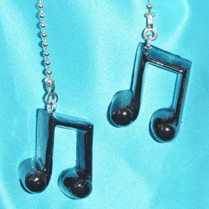 May include: Two black musical note shaped fan pull chains. The chains are silver and have small round beads.