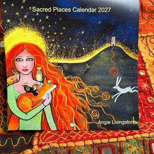 Puede incluir: Un calendario de pared cuadrado titulado Sacred Places Calendar 2027 de Angie Livingstone. La portada presenta una pintura de una persona con cabello largo y rojo sosteniendo un zorro, un b&uacute;ho y dos p&aacute;jaros. Una liebre blanca corre por un paisaje oscuro.