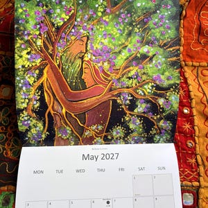 Puede incluir: Un calendario de pared para mayo de 2027 titulado Beltane Lovers, con una pintura de dos figuras fusion&aacute;ndose con un &aacute;rbol. El &aacute;rbol tiene ramas marrones, hojas verdes y flores moradas. La cuadr&iacute;cula del calendario muestra las fechas del 1 al 16.