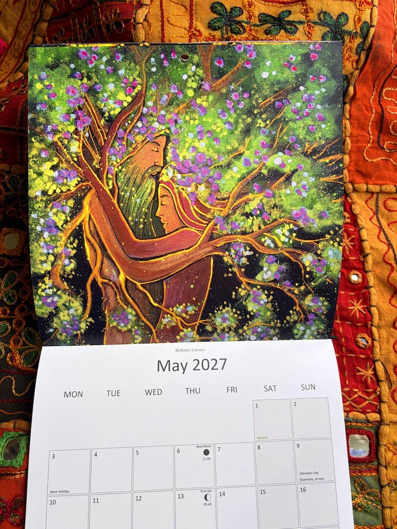 Puede incluir: Un calendario de pared para mayo de 2027 titulado Beltane Lovers, con una pintura de dos figuras fusion&aacute;ndose con un &aacute;rbol. El &aacute;rbol tiene ramas marrones, hojas verdes y flores moradas. La cuadr&iacute;cula del calendario muestra las fechas del 1 al 16.