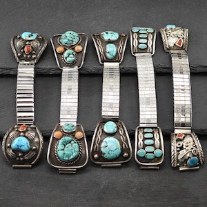 Puede incluir: Seis correas de reloj plateadas con detalles de turquesa y coral. Las correas son de metal y tienen un acabado plateado. Las piedras están engastadas en plata y son de diversas formas y tamaños.