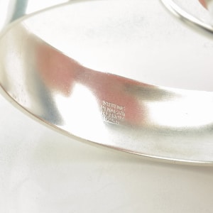 Peut inclure: Un bracelet jonc en argent avec l'inscription "STERLING DENMARK REFORM 925" &agrave; l'int&eacute;rieur.