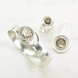 Peut inclure: Un ensemble de trois bijoux en argent avec des pierres de quartz fum&eacute;. L'ensemble comprend un bracelet, une bague et un pendentif.