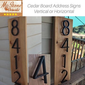 May include: Two cedar wood address signs with black metal numbers. The numbers are 8412. The signs are mounted vertically on a wooden fence.