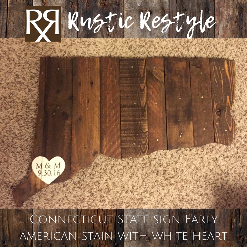 May include: Wooden sign shaped like the state of Connecticut, stained in a dark brown color with a white heart in the lower left corner. The heart has the initials "M & M" and the date "9.30.16" inscribed on it. The sign reads "CONNECTICUT STATE SIGN EARLY AMERICAN STAIN WITH WHITE HEART".