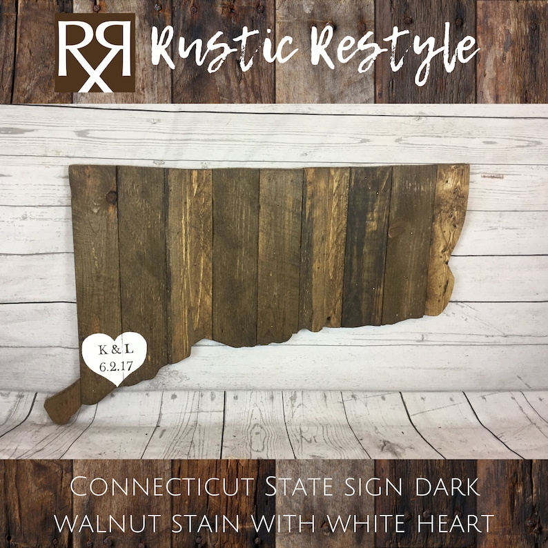 May include: A wooden state sign of Connecticut in the shape of the state with a white heart in the center. The heart has the initials "K&L" and the date "6.2.17" inside. The sign is stained dark walnut and has a rustic look. The sign is on a white wooden background.  CONNECTICUT STATE SIGN DARK WALNUT STAIN WITH WHITE HEART