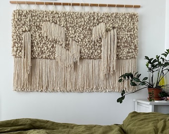 A large scale monochrome wool wall decoration, tapestry, fiber art in ivory, beige, white.