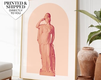 May include: A pink and white print of a statue of a woman wearing a helmet and a flowing robe. The statue is standing in an archway with a peach background.