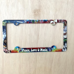 May include: A colorful metal license plate frame featuring images of famous musicians and the text "Peace, Love & Music".