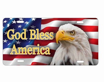 May include: Rectangular license plate featuring the American flag and a bald eagle. The words "God Bless America" are in yellow text. The eagle has white feathers, a yellow beak, and a focused gaze.