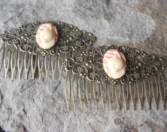 May include: Two gold hair combs with ornate filigree designs and pink and white cameo accents.