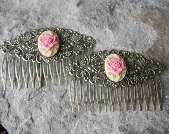 May include: Two gold hair combs with intricate filigree designs and pink rose cameo accents.