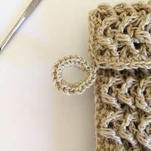 A close of up the small hanging loop on the left of the soap saver. It has a lovely v shaped crocheted stitch and is small enough to hang on a small hook in the shower.