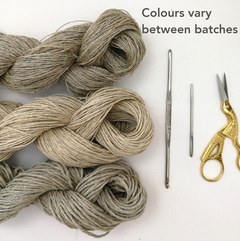 Three skeins of yarn half in the photo from the left laid horizontally and parallel to each other. Each skein is a different colour. From warm grey to beige and light grey. Grey text on a white background says Colours vary between batches