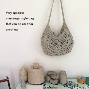 The mushroom patterned bag is hanging from a hook against an off white background. It is to the right of the photo and on the left there is black text which reads "Very spacious messenger style bag that can be used for anything".
