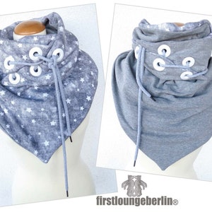 May include: Gray cowl neck scarf with white stars and white grommets and laces. The scarf is tied in a knot at the front.