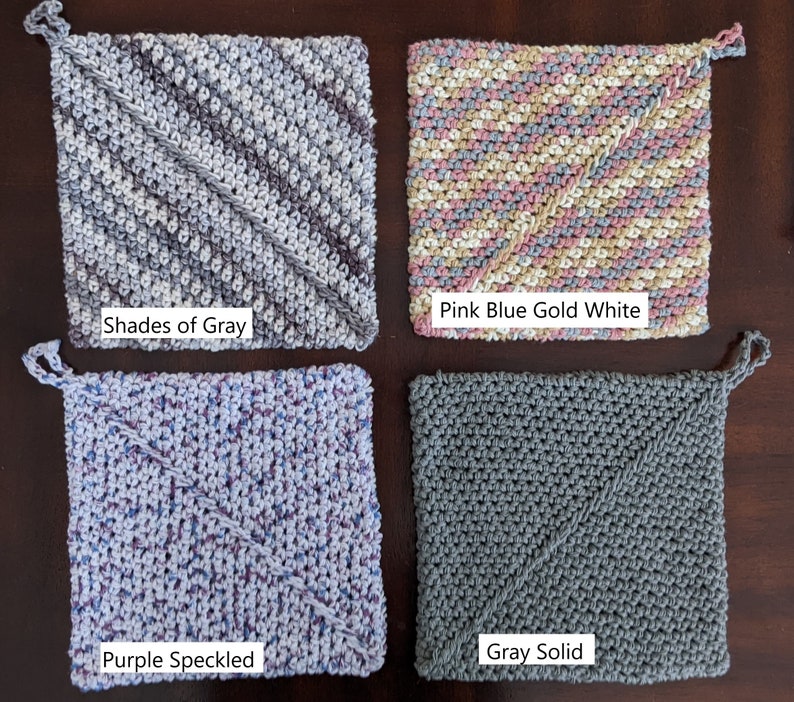 May include: Four crocheted pot holders in different color combinations.  The pot holders are square shaped with a diagonal stitch pattern.  The colors are: Shades of Gray, Pink Blue Gold White, Purple Speckled, and Gray Solid.