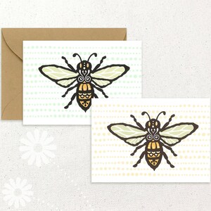 Peut inclure: Deux cartes de vœux avec une illustration d'abeille. L'abeille est noire et jaune avec des détails complexes. La carte de gauche a un fond vert avec des points blancs. La carte de droite a un fond jaune avec des points blancs.