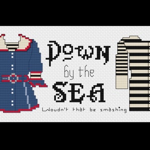 May include: Cross-stitch pattern featuring two outfits, one blue with a white collar and belt, and the other black and white striped. The text reads "Down by the Sea" and "Wouldn't that be smashing."