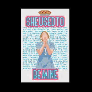 May include: A cross-stitch pattern featuring a woman in a blue dress with a pie on her head. The text reads "She Used To Be Mine".