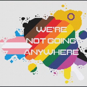 May include: A rainbow-coloured background with the text "WE'RE NOT GOING ANYWHERE" in white. The background is made up of different coloured splotches, including black, brown, blue, pink, purple, green, yellow, and white. The text is centred on the background.