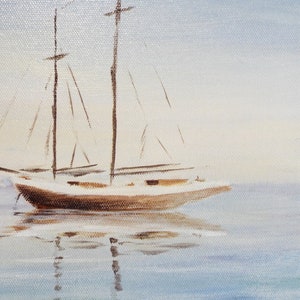 May include: A white sailboat with brown masts and sails is anchored in calm, blue water. The sky is a light blue with a hint of white clouds.