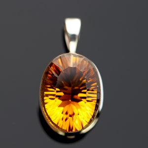 May include: A silver pendant with a large, oval-shaped, faceted, golden-amber gemstone.