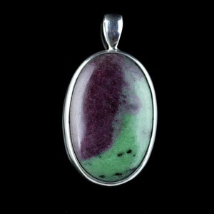 May include: A silver pendant with a green and purple oval gemstone. The gemstone has a swirling pattern of green and purple.