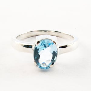 Puede incluir: Un anillo de plata con una piedra ovalada azul claro.