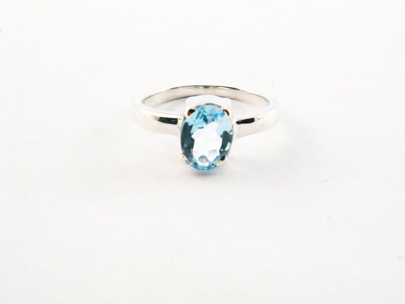 Puede incluir: Un anillo de plata con una piedra ovalada azul claro.