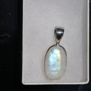 May include: A silver pendant with a white oval moonstone.