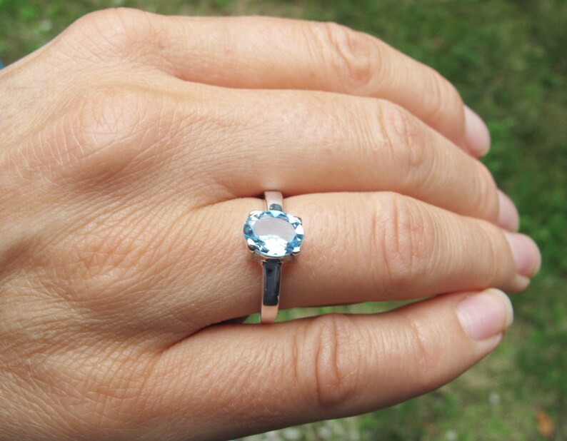 Puede incluir: Un anillo de plata con una piedra ovalada azul claro.