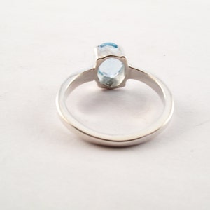 Puede incluir: Un anillo de plata con una piedra ovalada azul claro.