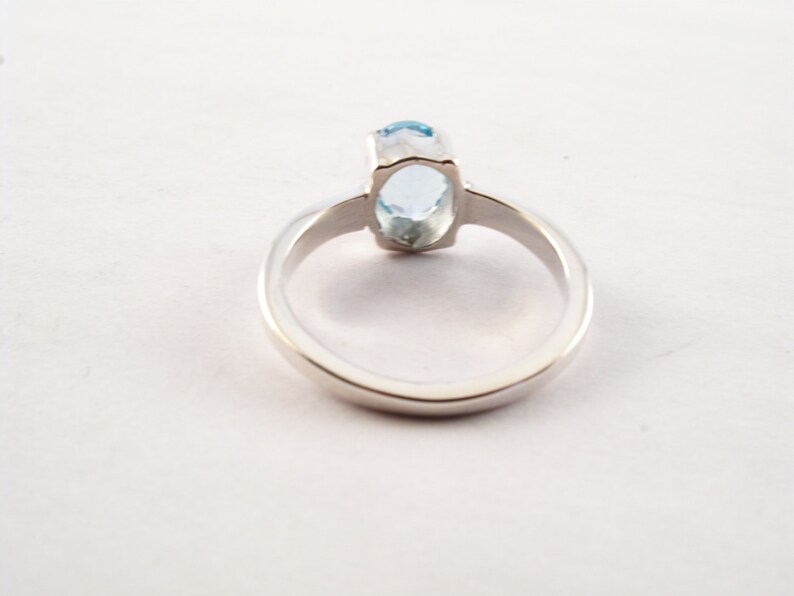 Puede incluir: Un anillo de plata con una piedra ovalada azul claro.
