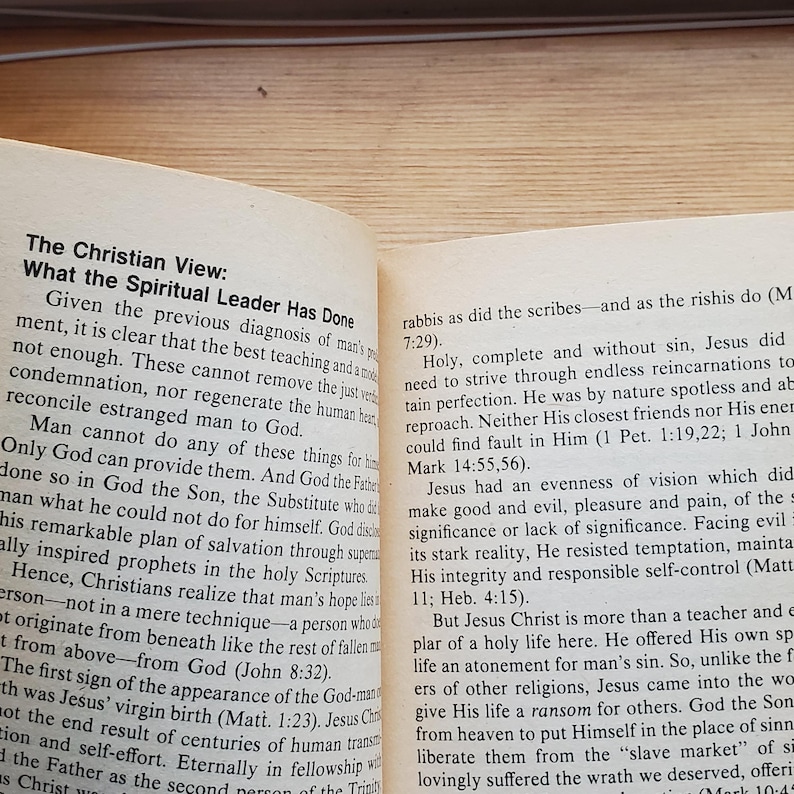 May include: Open book with text about Christian views on the spiritual leader. The text is in black font on aged, yellowed paper. The book is open to a double-page spread.