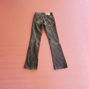 May include: A pair of dark brown corduroy pants with a straight leg and a slight flare at the bottom.