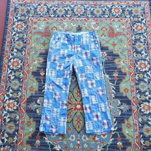 May include: Blue patchwork pants with a checkered pattern. The pants have a wide leg and a high waist.