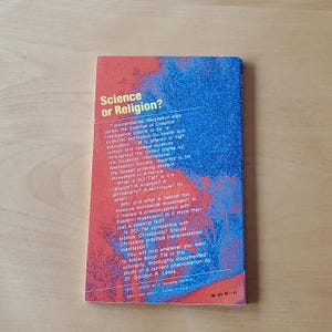 May include: The back cover of a book titled "Science or Religion?" features text in white and red on a blue background. The book discusses Transcendental Meditation, its claims, and its compatibility with Christianity. The cover design is by C. Howard Spurgeon.